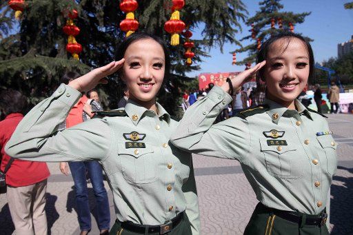 (111002) -- BEIJING Oct. 2 2011 (Xinhua) -- A pair of twin sisters salute during the 8th Beijing twins cultural festival held in the Honglingjin park in Beijing capital of China Oct. 2 2011. Hundreds pairs of twins across the country took part ...