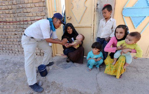 (110919)-- HEART Sept. 19 2011 (Xinhua) -- An Afghan health worker gives polio vaccine to a child in Heart city capital of western Heart province on Monday Sept. 19 2011. Afghanistan launched a three-day nationwide polio vaccination in order to ...