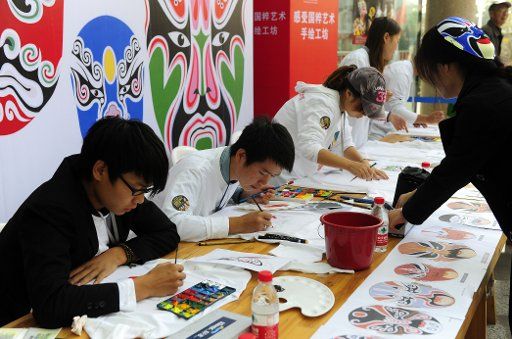 (111103) -- WUHAN Nov. 3 2011 (Xinhua) -- Students majored in Art draw Peking Opera facial masks on T-shirts during the 6th China Peking Opera Art Festival in Wuhan capital of central China\