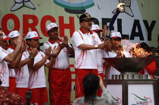 (111104) -- Jakarta Nov.4 2011 (Xinhua)-- City Governor Fauzi Bowo (C) lights up the cauldron with his torch during a torch relay ahead of the 26th Southeast Asian (SEA) Games in Jakarta Indonesia Nov. 4 2011. The Games will be held from Nov. ...