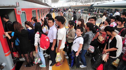 (121007) -- JIUJIANG, Oct. 7, 2012 (Xinhua) -- Passengers queue to get on a train at the Jiujiang railway station in Jiujiang, east China\