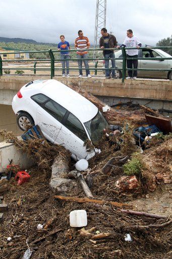 (120930) -- MALAGA, Sept. 30, 2012 (Xinhua) -- People look at a car that remains stranded after a flood in Malaga, Spain, on Sept. 29, 2012. A total number of 10 people died as the result of heavy rainfall hitting the south-east of Spain over the ...