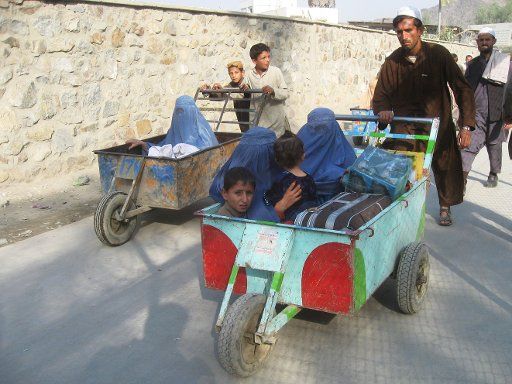 (121101) -- TORKHAM, Nov. 1, 2012 (Xinhua) -- Afghan families sit on the carts pushed by men as they enter Afghanistan through Torkham, a border town in Afghan eastern Nangarhar province which connects Afghanistan to the Peshawar city of Pakistan, ...