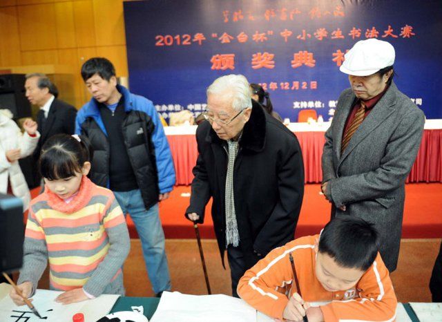 (121203) -- BEIJING, Dec. 3, 2012 (Xinhua) -- Yuan Xikun (R, back), curator of Jintai Art Museum in Beijing, and calligrapher Liu Yi (2nd R, back) watch the awarded young winners create calligraphic works at the award ceremony of the 2012 Annual "...