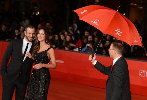(121118) -- ROME, Nov. 18, 2012 (Xinhua) -- A staffer prepares an umbrella for actors on the red carpet for the sudden rain before the awarding ceremony of the 7th Rome Film Festival in Rome, Italy, Nov. 17, 2011. (Xinhua\/Wang Qingqin)