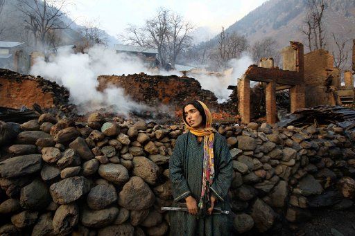 (121125) -- SRINAGAR, Nov. 25, 2012 (Xinhua) -- A Kashmiri Muslim woman looks at the debris after a fire accident at village Fraslan of Pahalgam, some 110 kilometres south of Srinagar, summer capital of Indian-controlled Kashmir, Nov. 25, 2012. A ...