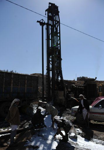(130101) -- SANAA, Jan. 1, 2013 (Xinhua) -- Yemeni villagers stand next to a well drilling rig on the outskirts of Sanaa, Yemen, Jan. 1, 2013. Yemen is one of the most arid countries on the earth and relies almost exclusively on groundwater for its ...