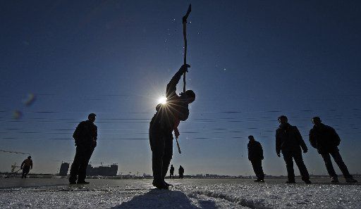 (121229) -- YINCHUAN, Dec. 29, 2012 (Xinhua) -- Fishermen make a hole in the ice surface to catch fish at Yuehai park in Yinchuan, capital of northwest China\