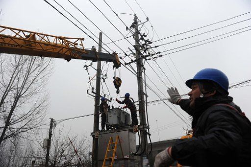 (130131) -- LINQUAN, Jan. 31, 2013 (Xinhua) -- Electricians install a transformer in Xiangtang Community of Linquan County in Fuyang City of east China\