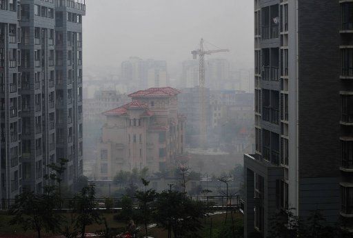 (130211) -- NANNING, Feb. 11, 2013 (Xinhua) -- Photo taken on Feb. 11, 2013 shows the buildings in downtown area enshrouded in misty rain in Nanning, capital of southwest China\