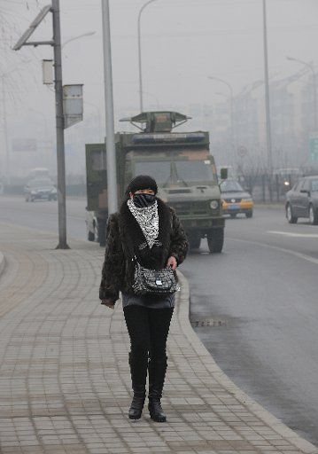 (130128) -- BEIJING, Jan. 28, 2013 (Xinhua) -- A citizen walks on the fog-shrouded Lianshi Road in Beijing, capital of China, Jan. 28, 2013. The National Meteorological Center (NMC) issued a blue-coded alert on Jan. 27 as foggy weather forecast for ...