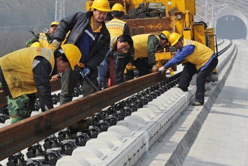 (130301) -- HUZHOU, March. 1, 2013 (Xinhua) -- Construction workers and engineers examine rail tracks in the Huzhou Railway Station in Huzhou, east China\