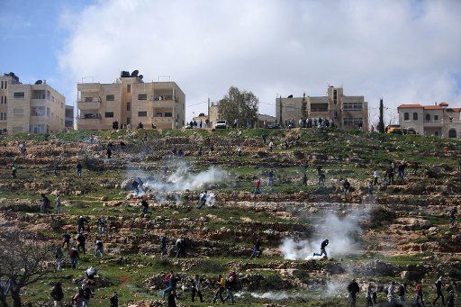 (130215) -- RAMALLAH, Feb. 15, 2013 (Xinhua) -- Palestinians run to take cover from tear gas fired by Israeli soldiers outside Ofer Prison near the West Bank city of Ramallah on Feb. 15, 2013, during a protest supporting a Palestinian prisoner on ...