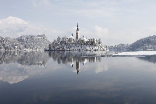 (130223) -- LJUBLJANA, Feb. 23, 2013 (Xinhua) -- A church and a castle are seen at Lake Bled in northwestern Slovenia, Feb. 23, 2013. A heavy snowfall on Friday night shrouded the beautiful glacial lake, a popular tourist destination about 55km from ...