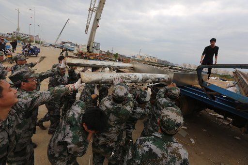 (130320) -- DAOXIAN, March 20, 2013 (Xinhua) -- Rescuers clear wind-torn billboards in Daoxian County, central China\