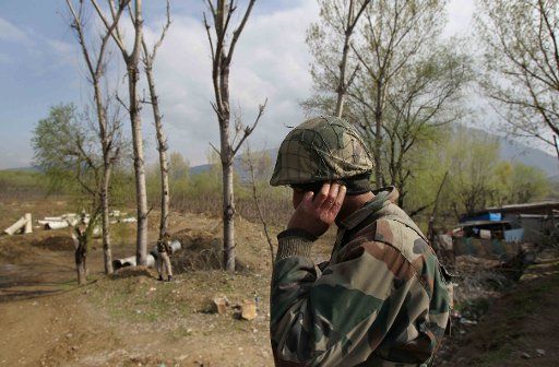 (130321) -- SRINAGAR, March 21, 2013 (Xinhua) -- An Indian border guard talks on phone after a truck was attacked by militants in Srinagar, summer capital of Indian-controlled Kashmir, March 21, 2013. At least three border guards of India\