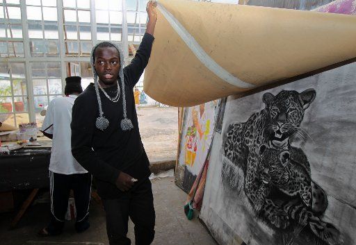 (130416) -- NAIROBI, April 16, 2013 (Xinhua) -- A man named Phillip Akatu shows his leopard charcoal drawing to visitors at the GoDown Arts Center in Nairobi, capital of Kenya, April 16, 2013. The GoDown Arts Center is located in the fringe of the ...