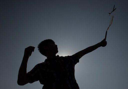 (130616) -- CHONGQING, June 16, 2013 (Xinhua) -- A student is silhouetted as he setting off a model aeroplane in southwest China\
