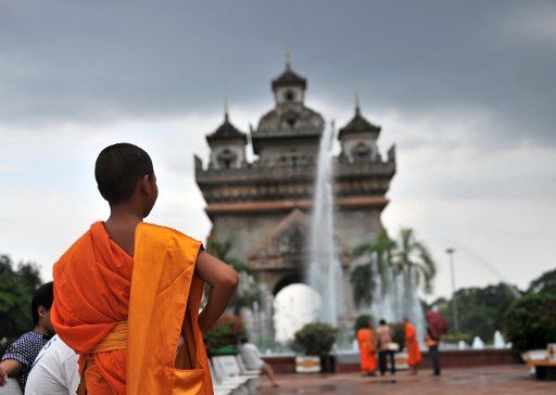 (130603) -- VIENTIANE, June 3, 2013 (Xinhua) -- A monk walks in front of the Patuxay Gate in Vientiane, Laos, June 2. 2013. (Xinhua\/Gao Jianjun) (zhf)