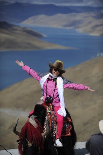 (130608) -- LHASA, June 8, 2013 (Xinhua) -- A tourist poses for photos beside the Yamzhog Yumco Lake in Shannan Prefecture, southwest China\