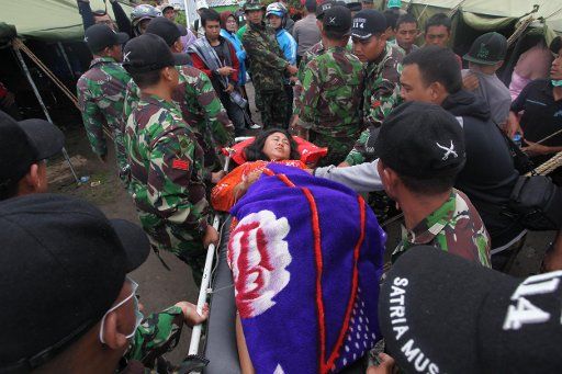 (130705) -- ACEH, July 5, 2013 (Xinhua) -- The rescue team evacuates an earthquake survivor to the refugee camp at Blang Pancung village, Aceh, Indonesia, July 4, 2013. The death toll from an earthquake that hit Indonesia\