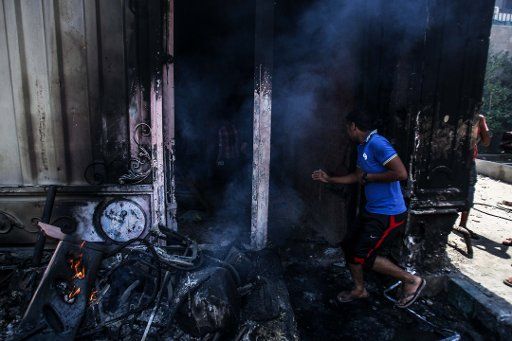 (130701) -- CAIRO, July 1, 2013 (Xinhua) -- An Egyptian opposition protester runs into the burning Muslim Brotherhood headquarters building in Cairo, July 1, 2013. At least eight people were killed during overnight clashes outside the Muslim ...