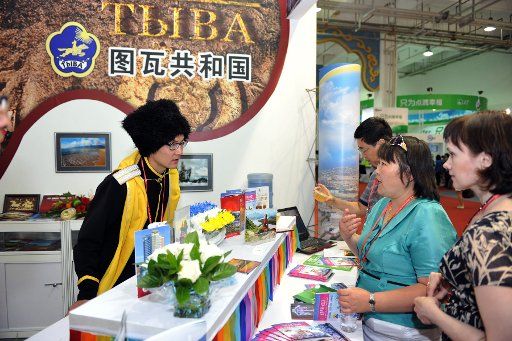(130719) -- HOHHOT, July 19, 2013 (Xinhua) -- A Russian staff member introduces commodities to visitors during the 7th China National Commodity Trade Fair in the International Conventional and Exhibition Center in Hohhot, capital city of north China\