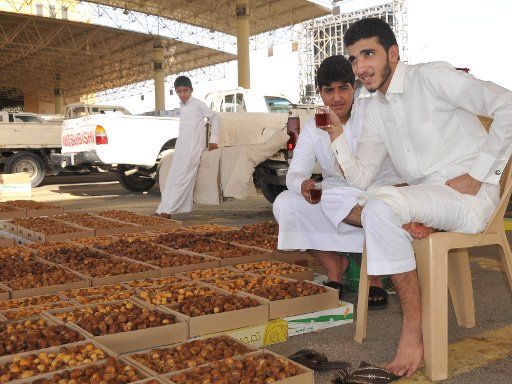 (130818) -- BURAIDAH, Aug. 18, 2013 (Xinhua) -- Salesmen drink red tea as they sell date palms at the world\