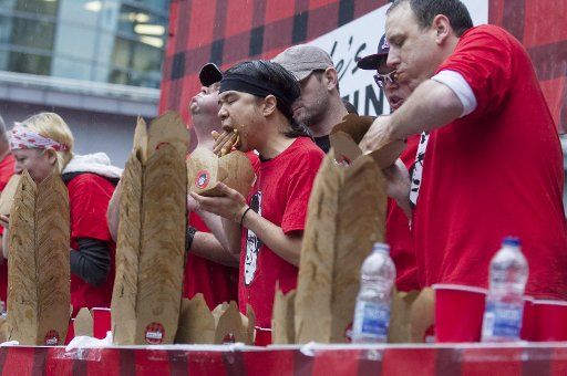 (20131020) -- TORONTO, Oct. 20, 2013 (Xinhua) -- Contestants take part in the 4th Annual World Poutine Eating Championship at Yonge-Dundas Square in Toronto, Canada, Oct. 19, 2013. American contestant, Joey Chestnut, won the champion after eating 24 ...