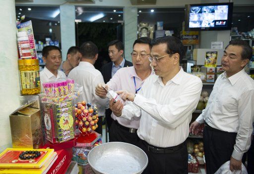 (131014) -- HANOI, Oct. 14, 2013 (Xinhua) -- Chinese Premier Li Keqiang (2nd R) shops at a local store near his hotel in Hanoi, Vietnam, Oct. 14, 2013. Li landed here Sunday for an official visit to Vietnam. (Xinhua\/Huang Jingwen) (mp)