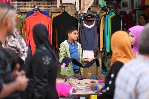 (131015) -- BETHLEHEM, Oct. 15, 2013 (Xinhua) -- A Palestinian street vendor sells clothes ahead of the Muslim festival Eid al-Adha in the West Bank city of Bethlehem, on Oct. 14, 2013. Muslims across the world are preparing to celebrate the annual ...