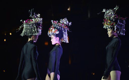 (131015) -- FENGHUANG, Oct. 15, 2013 (Xinhua) -- Models present creations during a fashion show held on the Tuojiang River in the ancient town of Fenghuang in Fenghuang County of Xiangxi Tu and Miao Autonomous Prefecture, central China\