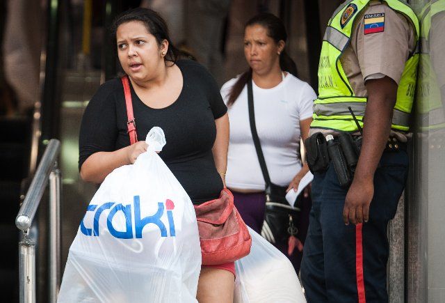 (131117) -- CARACAS, Nov. 17, 2013 (Xinhua) -- Residents leave after shopping at the retail super store Traki in Caracas, capital of Venezuela, on Nov. 16, 2013. According to Venezuelan President Nicolas Maduro\