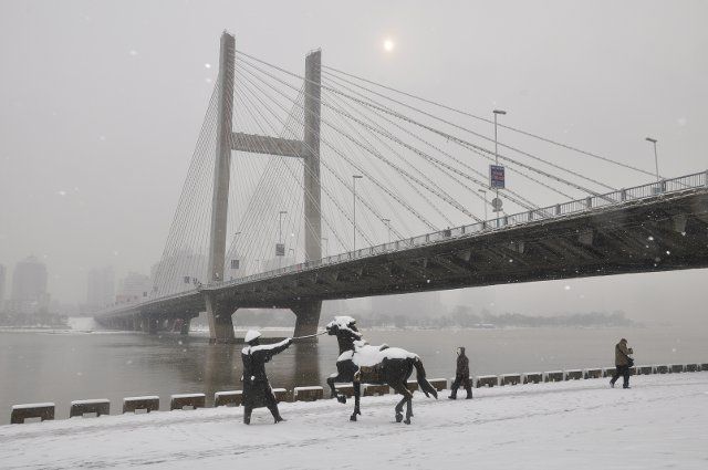 (131117) -- JILIN, Nov. 17, 2013 (Xinhua) -- People walk in the snow on a street in Jilin City, northeast China\