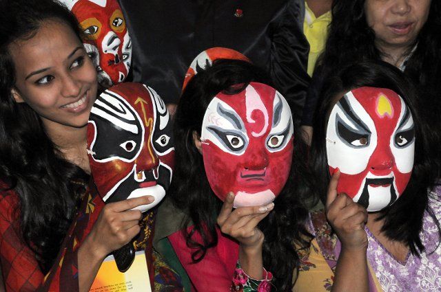 (131122) -- DHAKA, Nov. 22, 2013 (Xinhua) -- Visitors wear Beijing Opera masks during a Beijing Opera masks exhibition at the Confucius Institute at the North South University in Dhaka, Bangladesh, Nov. 22, 2013. The three-day Beijing Opera masks ...