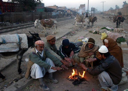 (140104) -- PESHAWAR, Jan. 4, 2014 (Xinhua) -- Pakistanis warm themselves around a fire during a cold day in northwest Pakistan\