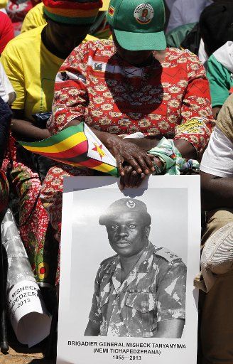 (131209) -- HARARE, Dec. 9, 2013 (Xinhua) -- Zimbabweans pray during the grand burial ceremony of national hero, former defense attache to China, Brigadier-General Misheck Tanyanyiwa in Harare, capital of Zimbabwe, Dec. 8, 2013. Brigadier-General ...