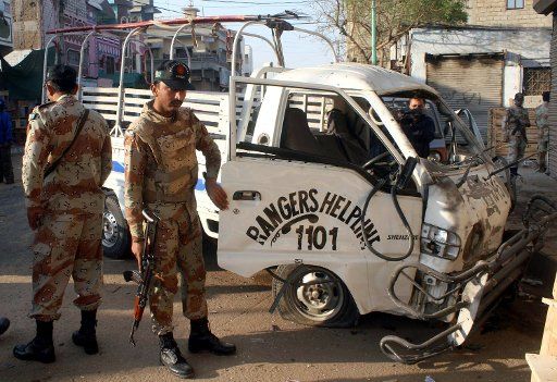 (131212) -- KARACHI, Dec. 12, 2013 (Xinhua) -- Pakistani soldiers inspect a damaged paramilitary van at the blast site in southern Pakistani port city of Karachi on Dec. 12, 2013. At least one soldier was killed and seven others were injured in a ...