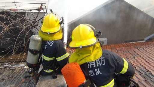 (140115) -- NANJING, Jan. 15, 2014 (Xinhua) -- Fire fighters spray water to a burnt house on Xinglong Street, Nanjing, capital of east China\