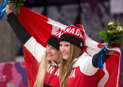 (140219) -- SOCHI, Feb. 19, 2014 (Xinhua) -- Gold medalists Kaillie Humphries (L) and Heather Moyse of Canada celebrate during the flower ceremony for women\
