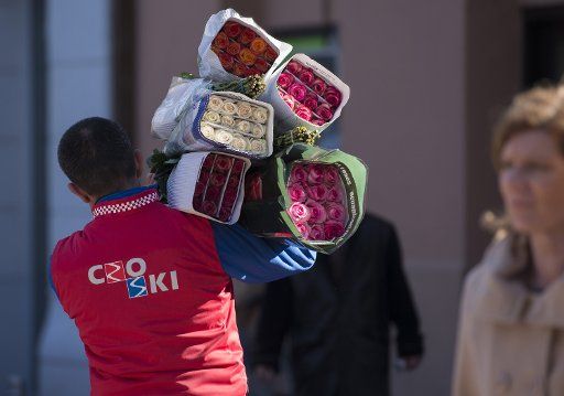 (140214) -- ZAGREB, Feb. 14, 2014 (Xinhua) - A salesman carries bunches of roses at the flower market in downtown Zagreb, capital of Croatia, Feb. 13, 2014. (Xinhua\/Miso Lisanin)