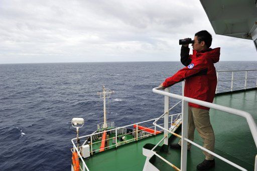 (140323) -- ABOARD XUELONG, March 23, 2014 (Xinhua) -- A Chinese Antarctic exploration team member aboard Chinese icebreaker Xuelong (Snow Dragon), searches for missing Malaysian Airlines flight MH370 over the southern Indian Ocean, March 23, 2014. ...