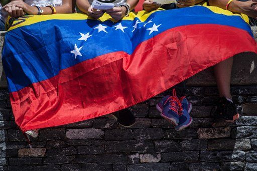 (140303) -- CARACAS, March 3, 2014 (Xinhua) -- Demonstrators are covered with a national flag of Venezuela during a anti-government protest in Caracas, Venezuela, on March 3, 2014. (Xinhua\/Boris Vergara)