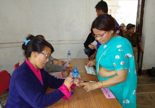 (140412) -- GANGTOK, April 12, 2014 (Xinhua) -- A polling officer marks the finger of a voter with ink at a polling booth in Gangtok, capital of India\