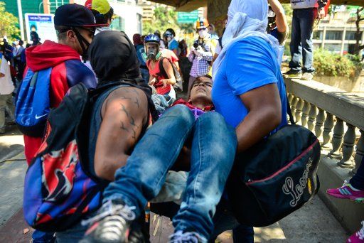 (140413) -- CARACAS, April 13, 2014 (Xinhua) -- Demonstrators carry an injured person during an anti-government protest in Las Mercedes, Caracas, Venezuela, on April 12, 2014. (Xinhua\/Carlos Becerra) (fnc)