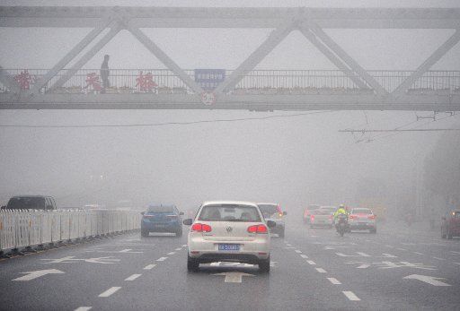 (140326) -- WUHAN, March 26, 2014 (Xinhua) -- Vehicles run amid fog in Wuhan, capital of central China\
