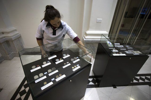 (140612) -- BUENOS AIRES, June 12, 2014 (Xinhua) -- An employee cleans a cabinet where conmemorative coins of World Cups are displayed during the opening of the Soccer World Championships exhibition at the Historical and Numismatic Museum of the ...
