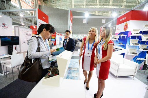(140703) -- HARBIN, July 3, 2014 (Xinhua) -- Russian exhibitors communicate with a Chinese dealer at the China-Russia Expo (CR Expo) in Harbin, capital of northeast China\