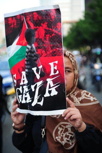 (140710) -- JAKARTA, July 10, 2014 (Xinhua) -- An Indonesian protester holds a placard during a rally in Jakarta, Indonesia, July 10, 2014. Indonesia condemned the ongoing Israeli military aggression in Gaza Strip, saying such an onslaught may ruin ...