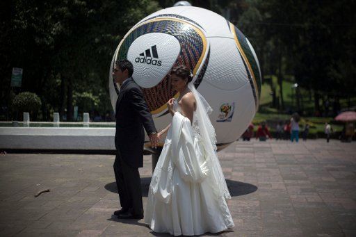 (140712) -- MEXICO CITY, July 12, 2014 (Xinhua) -- A couple walk by a football model, which is part of an exposition of giant replicas of official footballs used by FIFA Wolrd Cup tournaments, in the "Parque Hundido" of Mexico City, capital of ...